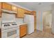 Functional kitchen featuring white appliances, stove, tile floors, and wood cabinetry at 8725 W Flamingo Rd # 240, Las Vegas, NV 89147