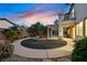 Manicured backyard with a covered patio, circular garden, and lush plantings at 9008 Sawhill Pond St, Las Vegas, NV 89131