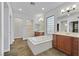 Luxurious bathroom with double vanity, soaking tub, a separate glass-enclosed shower, and neutral tile flooring at 9008 Sawhill Pond St, Las Vegas, NV 89131