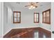 Bedroom with hardwood floors, a ceiling fan, and two windows with wooden shutters at 9008 Sawhill Pond St, Las Vegas, NV 89131