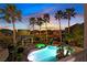 Backyard oasis with a sparkling pool, rock waterfall feature, spa, and covered patio at 9008 Sawhill Pond St, Las Vegas, NV 89131