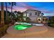 Lush backyard with a sparkling pool, hot tub, rock features, and an inviting outdoor seating area at 9008 Sawhill Pond St, Las Vegas, NV 89131