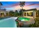 Resort-style backyard with a pool, integrated spa, rock features, and covered patio at 9008 Sawhill Pond St, Las Vegas, NV 89131