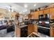 Bright kitchen featuring dark appliances, tile backsplash, custom cabinets, and view to a living space at 9060 Watermelon Seed Ave, Las Vegas, NV 89143