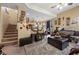 Cozy living room with neutral color scheme and plush seating, adjacent to staircase and kitchen at 9060 Watermelon Seed Ave, Las Vegas, NV 89143