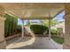 Covered back patio with brick retaining wall and lush landscaping at 9664 Emeraude Ave, Las Vegas, NV 89147