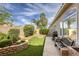 Inviting backyard features manicured landscaping, artificial grass, and a built-in fire pit, perfect for outdoor entertaining at 9664 Emeraude Ave, Las Vegas, NV 89147