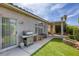 Backyard features artificial grass, a built-in BBQ, a covered patio, and manicured landscaping at 9664 Emeraude Ave, Las Vegas, NV 89147