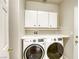 Laundry room with white cabinets, front load washer and dryer at 9664 Emeraude Ave, Las Vegas, NV 89147