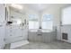 Bright bathroom with large tub, white cabinets, double windows, and stylish tile flooring at 11244 Playa Caribe Ave, Las Vegas, NV 89138