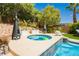Inviting backyard featuring a hot tub, lush greenery, and comfortable lounge furniture at 11244 Playa Caribe Ave, Las Vegas, NV 89138