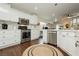 Modern kitchen featuring white cabinets, stainless steel appliances, granite countertops, and hardwood floors at 11244 Playa Caribe Ave, Las Vegas, NV 89138