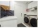 Bright laundry room with modern washer and dryer, countertop, and black subway tile backsplash at 11244 Playa Caribe Ave, Las Vegas, NV 89138