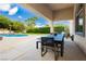 Covered patio with an outdoor dining set, view of the pool and a beautifully landscaped yard at 11244 Playa Caribe Ave, Las Vegas, NV 89138