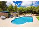 Inviting backyard oasis with a sparkling pool, lounge chairs, umbrellas, and lush landscaping at 11244 Playa Caribe Ave, Las Vegas, NV 89138