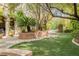 Serene backyard with mature trees, manicured lawn, and a stone patio at 11814 Canons Brook Dr, Las Vegas, NV 89141