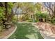 Beautiful backyard with a manicured lawn, stone pathway, and verdant landscaping at 11814 Canons Brook Dr, Las Vegas, NV 89141