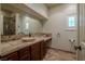 This bathroom includes a large vanity, dark wooden cabinets, a vessel sink, and a tiled shower at 11814 Canons Brook Dr, Las Vegas, NV 89141
