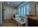 Bright bathroom features a soaking tub with dark hardware, tile surround, and natural light from a window at 11814 Canons Brook Dr, Las Vegas, NV 89141