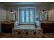 Bathroom featuring tiled tub and deck next to large window, dual vanities, and travertine floors at 11814 Canons Brook Dr, Las Vegas, NV 89141