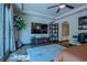 This bedroom includes wood floors, a ceiling fan, backyard access, a large TV, and display shelving at 11814 Canons Brook Dr, Las Vegas, NV 89141