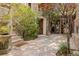 Private courtyard with stone tile flooring, lush plants, and a decorative doorway at 11814 Canons Brook Dr, Las Vegas, NV 89141
