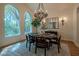 Elegant dining room with large windows, wood floors, chandelier, and seating for six at 11814 Canons Brook Dr, Las Vegas, NV 89141