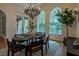 Formal dining room with large windows, elegant chandelier and a backyard view at 11814 Canons Brook Dr, Las Vegas, NV 89141