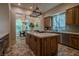 Open kitchen with wood cabinets, center island, stone flooring, and view to dining area at 11814 Canons Brook Dr, Las Vegas, NV 89141