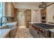 Spacious kitchen features wood cabinetry, an island with a cooktop, and tiled backsplash at 11814 Canons Brook Dr, Las Vegas, NV 89141