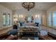 Bright living room with white textured walls, wood floors, and a decorative wrought iron chandelier at 11814 Canons Brook Dr, Las Vegas, NV 89141