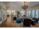 Spacious living room featuring a grand chandelier, arched doorways, and wood flooring at 11814 Canons Brook Dr, Las Vegas, NV 89141