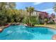 Sparkling pool and spa surrounded by lush greenery and a stone patio at 11814 Canons Brook Dr, Las Vegas, NV 89141