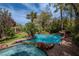 Beautiful pool and spa with a rock waterfall feature and manicured landscaping at 11814 Canons Brook Dr, Las Vegas, NV 89141