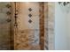 Custom tiled shower stall showcases beautiful tilework, bronze fixtures, and seating at 11814 Canons Brook Dr, Las Vegas, NV 89141