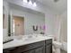 Well-lit bathroom features a large mirror, sleek vanity, and a shower-tub combination with neutral-toned shower curtain at 12391 Pinetina St, Las Vegas, NV 89141