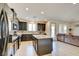 Spacious kitchen with stainless steel appliances, granite countertops, and island overlooks the living area at 12391 Pinetina St, Las Vegas, NV 89141