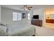 Spacious main bedroom with carpet flooring, ceiling fan, dresser with TV, and a doorway to bathroom at 12391 Pinetina St, Las Vegas, NV 89141