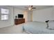 Spacious main bedroom with carpet flooring, ceiling fan, dresser with TV, and two windows at 12391 Pinetina St, Las Vegas, NV 89141