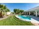 Landscaped backyard featuring a pool with a spa, a well-manicured lawn, and palm trees at 1341 Marina Del Rey Ct, Las Vegas, NV 89117