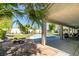 Inviting backyard oasis featuring a covered patio, pool, lush lawn, and mature trees at 1341 Marina Del Rey Ct, Las Vegas, NV 89117