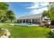 Lush backyard with a sparkling pool, covered patio, manicured lawn, and mature landscaping at 1341 Marina Del Rey Ct, Las Vegas, NV 89117
