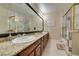 Bathroom with dual sinks features granite countertops, wood cabinets, and a large mirror above the sinks at 1341 Marina Del Rey Ct, Las Vegas, NV 89117