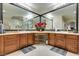 Bathroom with dual sinks, wood cabinets, and a seated vanity area features red flower arrangement on the countertop at 1341 Marina Del Rey Ct, Las Vegas, NV 89117
