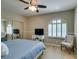 Bedroom with a window features a cozy chair, a TV on a desk, and a queen bed covered with a blue comforter at 1341 Marina Del Rey Ct, Las Vegas, NV 89117