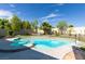 Inviting pool and spa area surrounded by a stone border, grass, and mature landscaping at 1341 Marina Del Rey Ct, Las Vegas, NV 89117