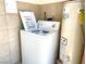 Laundry room features a white washing machine, beige tile, and a water heater at 1520 Henry Dr, Las Vegas, NV 89110