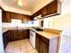Bright kitchen with white appliances, wood cabinets, and a tiled floor at 1524 Henry Dr, Las Vegas, NV 89110