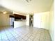 Open-concept living room with tile floors flowing into the kitchen area featuring dark wood cabinets at 1524 Henry Dr, Las Vegas, NV 89110