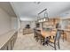 Open dining area that connects to a living room with a tan couch and a modern chandelier at 193 Glenbrook Estates Dr, Las Vegas, NV 89183